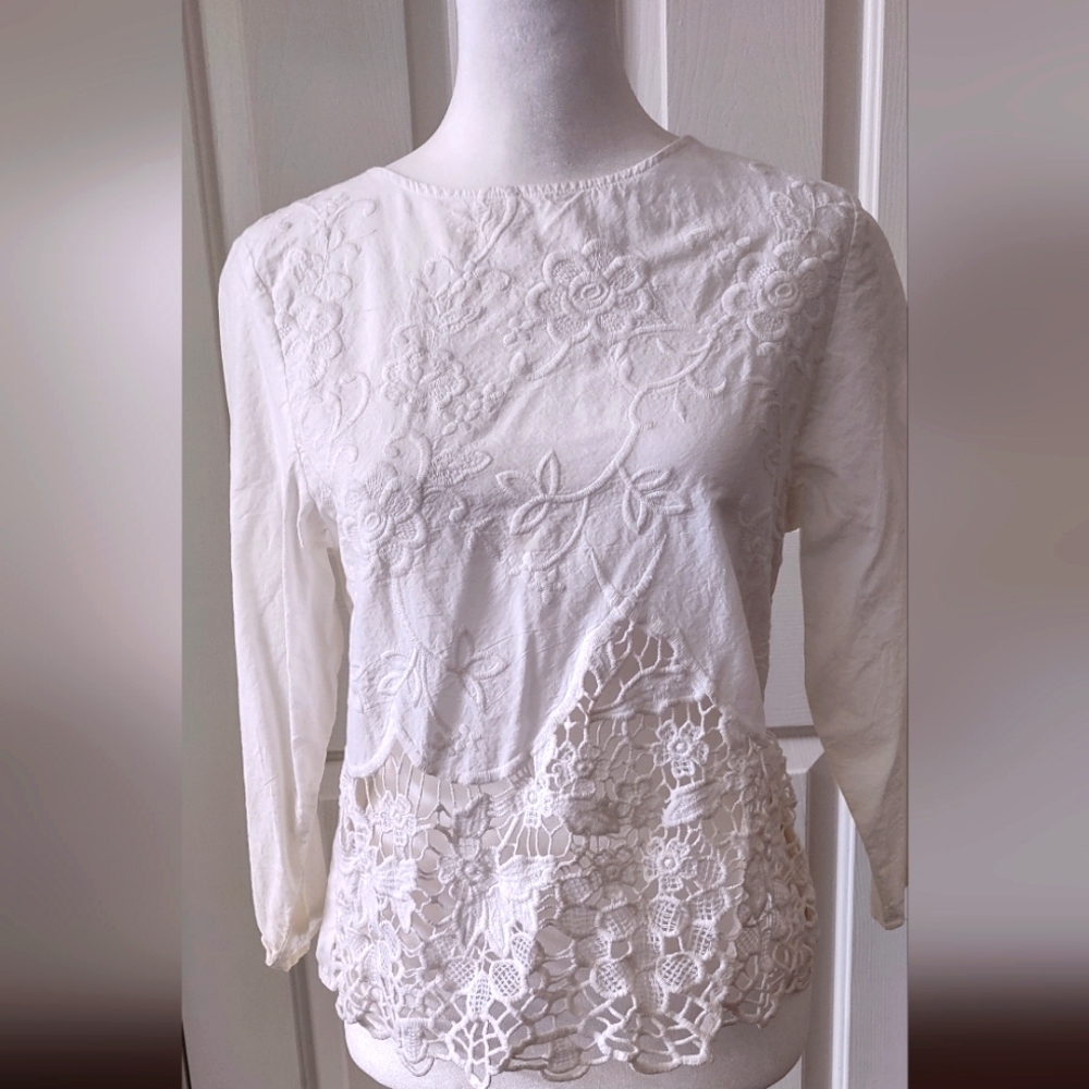 White 100% cotton women's shirt with open back and lace accents on front.